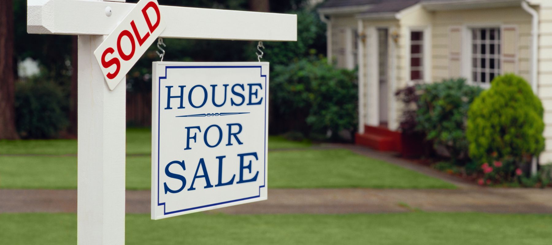house for sale sign with sold sticker attached
