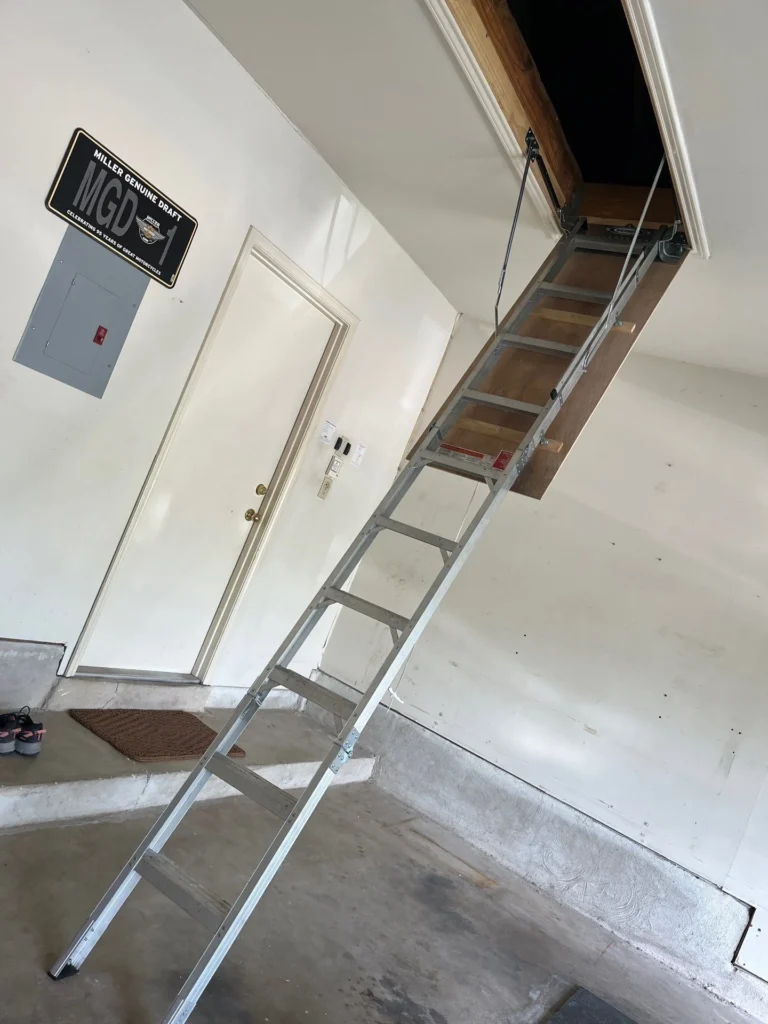 Fully extended aluminum attic ladder in a garage setting in a San Antonio home