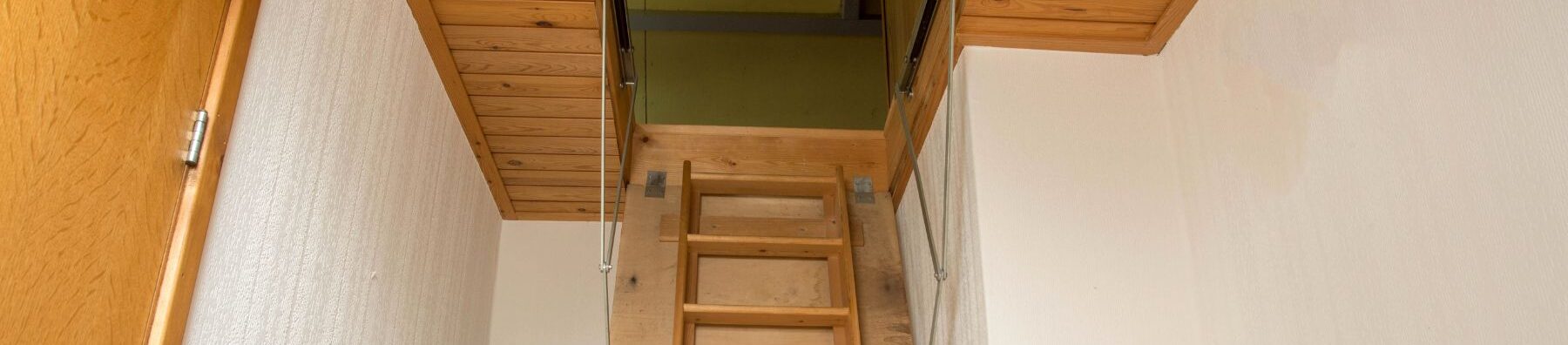 closeup of a attic ladder leading up to a residential attic